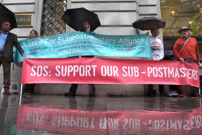 Как менеджеры становятся причиной ИТ-катастроф - 3 A crowd of protestors on a rainy day hold signs showing support for the Sub-postmasters.